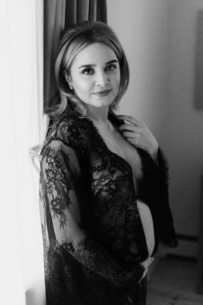 Pregnant woman wearing black lace maxi robe